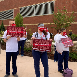 Nurses at HCA’s Mission Hospital hold signs for safe staffing and optimal PPE