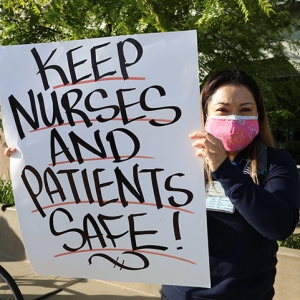 Nurse holds sign "Keep Nurses and Patients Safe"