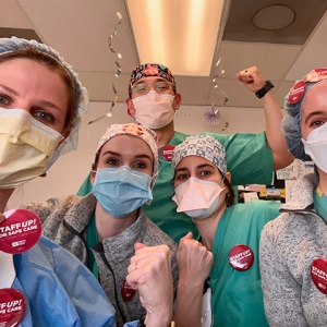 UC Davis nurses with fists raised and stickers "Staff up for safe care. End crisis care now"