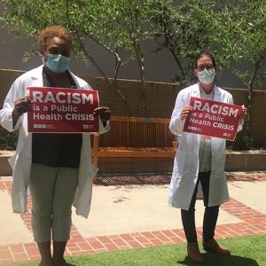 Nurses hold signs "Racism is a Public Health Crisis"