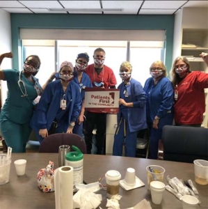 Group of nurses inside hospital with raised fists