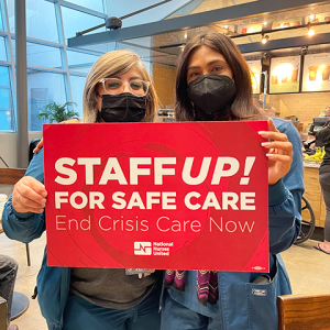 Two City of Hope nurses holding sign "Staff up! For safe care. End crisis care now."