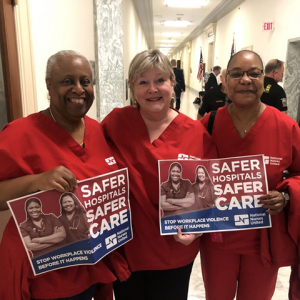 Nurses in DC government hallway with signs "Safer hospitals safer care. Stop workplace violence before it happens"