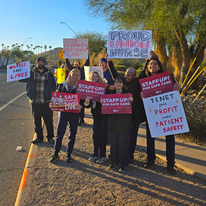 Nurses outside holding signs "Staff up for safe patient care"