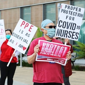 Nurses protesting for PPE holding signs "PPE is as essential as I am", "Proper protection for Covid-19 Nurses", "Every Nurse Protected Every Time", "Protect Nurses, Patients, Public Health"
