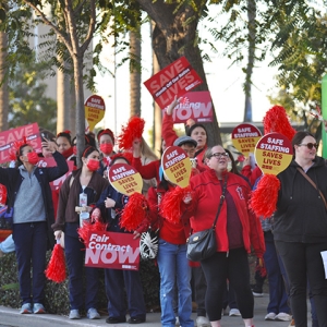 Nurses on picket line holding signs for safe staffing.