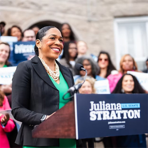 Juliana Stratton at podium with crowd behind her