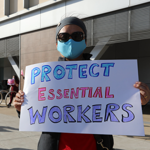 Nurse holds sign "Protect Essential Workers"