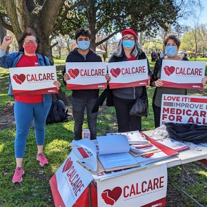 Group of four people all holding CalCare signs