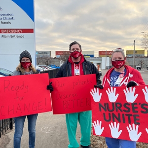 3 nurses hold signs "Ready for Change", "Our Patients Deserve Better", "Nurses Unite"