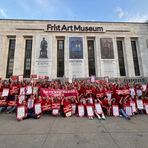 Large group of nurses outside Frist Art Museum holding banner "Patients Needs over HCA/Frist Greed"