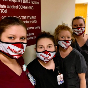 Four nurses inside hospital standing side-by-side