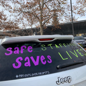 Back of car with "Safe Staffing Saves Lives" written on window