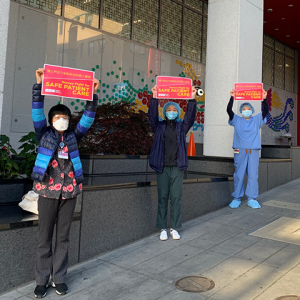 Registered nurses at Chinese Hospital hold sings saying "Nurses fight for safe patient care"