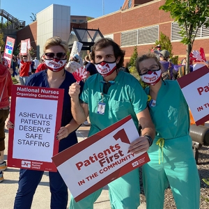 Group of three nurses outside Mission Hospital hold sign "Patients First"