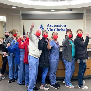 Group of nurses inside hospital giving thumbs up
