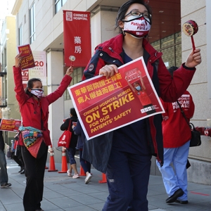 Nurse on picket line hold sign "Chinese Hospital Nurses On Strike for Our Patient's Safety"