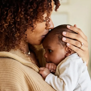 Mother holding baby on her shoulder