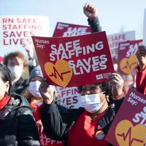 Nurses holding signs "Safe Staffing Saves Lives"