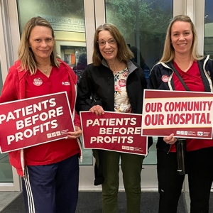 4 nurses from Desert Regional Medical Center holding signs "Patients before profits" and "Our community, our hospital"