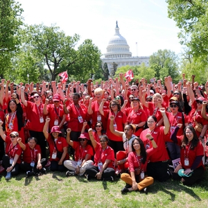 Large group of nurses outside Capitol building in Washington, D.C. with raised fists