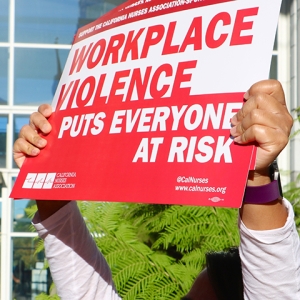 Nurse holding sign "Workplace Violence puts everyone at risk"