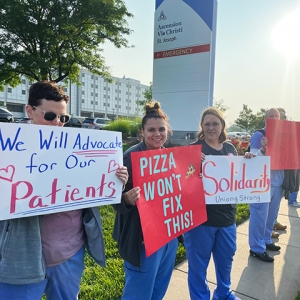 Nurses in front of Ascension Via Christi St. Joseph hospital holding picket