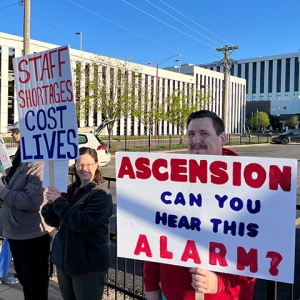 Nurse holds signs "Ascension can you hear this alarm?"