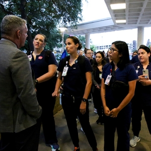 Nurse being confronted by management at entrance to hospital