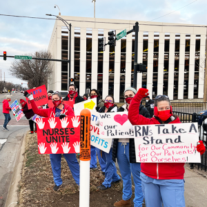 Nurses in front of St. Francis holding signs