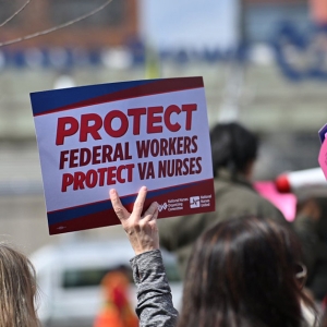 Demonstrators holding signs that read "Protect federal workers, protect VA nurses."