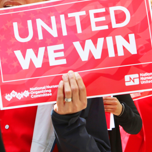 Nurse holding sign "United we win"