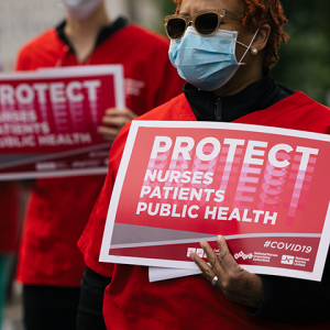 Nurses holds signs "Protect Nurses, Patients, Public Health"