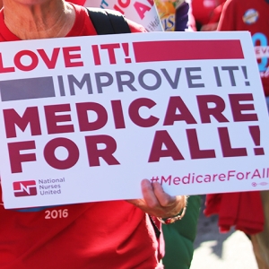 Person holding sign: "Love it, improve it, Medicare for All!"