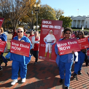 Nurse outside The Whitehouse holding signs "Stop Ebola Now"