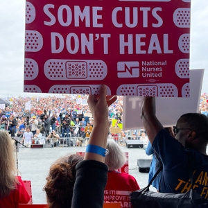 Hand holding sign "Some Cuts Don't Heal"