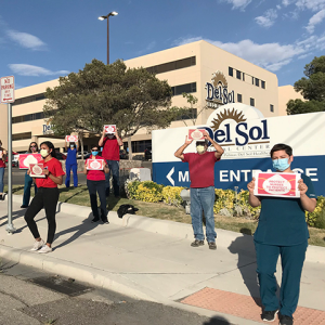 RNs outside hospital hold signs calling for safety measures