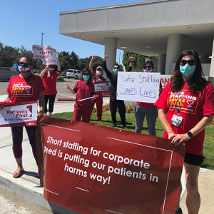 Nurses outside mission hospital hold signs calling for safe staffing