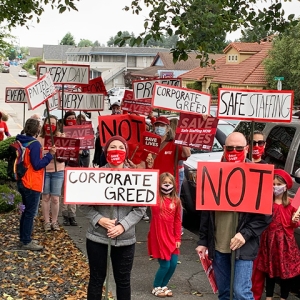 Large group of nurses and community holding signs calling for safe staffing 