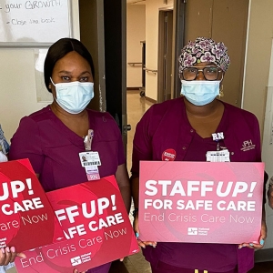 Nurses at Jackson Park Hospital hold signs that read "Staff up for safe care!"