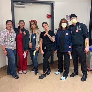 Group of six nurses inside hospital standing side-by-side