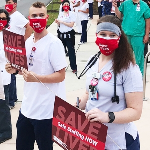 Nurses holding signs "Save Lives: Safe Staffing Now"