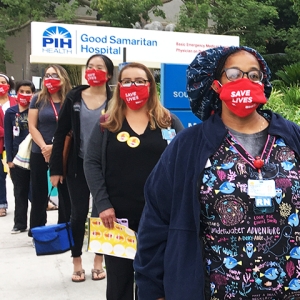 Nurses in front of Good Samaritan Hospital sign with masks "Save lives"