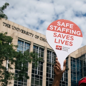 Hand holding sign "Safe Staffing Saves Lives"