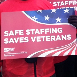 Hands hold sign "Safe Staffing Saves Veterans"