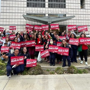 Large group of nurses outside holding signs "Ready to Fight"