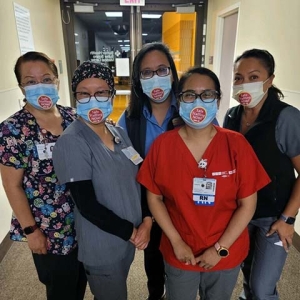 Five nurses in hospital wearing stickers that read "Safe Staffing Now"
