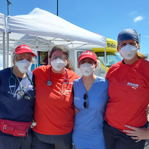 Four RNRN volunteers standing in front of tent