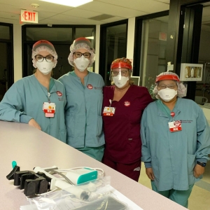 Group of four nurses inside hospital wearing masks