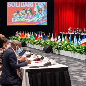 Nurses seating at tables in convention hall with their international flags